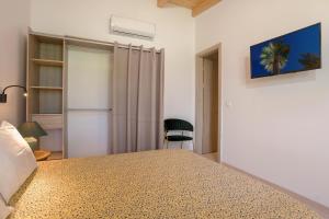 a bedroom with a bed and a chair in a room at Villa Alkis - Spacious Pool Retreat in Zakynthos