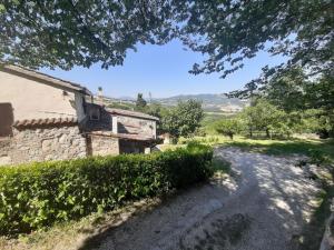 una carretera frente a un edificio de piedra con árboles en Tolles Ferienhaus in Urbino mit Grill, Garten und Terrasse, en Urbino