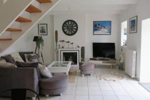 uma sala de estar com lareira e um relógio na parede em Maison de charme avec jardin clos, terrasse à PERROS-GUIREC - Ref 868 em Perros-Guirec