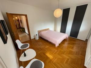 1 dormitorio con 1 cama, mesa y sillas en Ciasa Mia Nelle Dolomiti en Pieve di Cadore