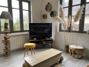 un soggiorno con TV, tavolo e sedie di Maison de charme 3 étoiles avec jardin clos terrasse PERROS-GUIREC - ref 869 a Perros-Guirec