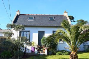 una casa bianca con palme di fronte di Maison de charme 3 étoiles avec jardin clos terrasse PERROS-GUIREC - ref 869 a Perros-Guirec