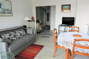 salon z kanapą i stołem w obiekcie Bel appartement avec loggia et balcon VUE SUR MER à PERROS-GUIREC - Réf 874 w mieście Perros-Guirec