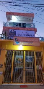 un edificio amarillo con una puerta delante en Villa Juan y Exequila, en Anda