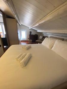 duas toalhas numa cama branca num quarto em VicomilleSuites Cagliari em Cagliari