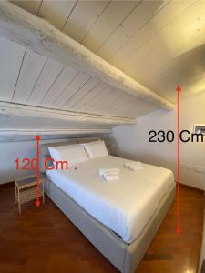 uma cama branca num quarto com duas setas vermelhas em VicomilleSuites Cagliari em Cagliari
