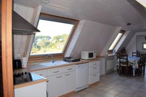 eine Küche mit einem Waschbecken und einem Fenster darin in der Unterkunft Appartement 5 pers sur la plage à Ploumanac'h, VUE MER à PERROS-GUIREC - Réf 897 in Perros-Guirec