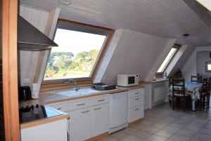 kuchnia ze zlewem i oknem w obiekcie Appartement 5 pers sur la plage à Ploumanac'h, VUE MER à PERROS-GUIREC - Réf 897 w mieście Perros-Guirec
