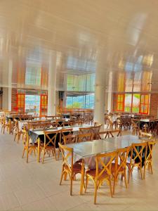 a large room with tables and chairs and windows at CASONA HOTEL LA DIVISA in Santa Rosa de Cabal