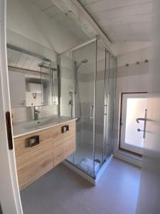 uma casa de banho com uma cabina de duche em vidro e um lavatório. em VicomilleSuites Cagliari em Cagliari