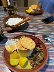 een bord voedsel op een tafel met eieren en rijst bij Ella Brown House in Ella