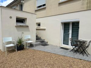 a patio with chairs and a table next to a building at Au coeur des Chateaux de la Loire in Fondettes