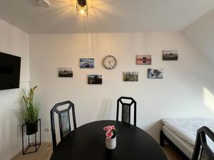 Una habitación con una mesa y un reloj en la pared. en Gemütliches Apartment für 2 Personen nahe RaumFabrik - Durlach by Rabe, en Karlsruhe