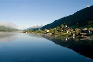 een grote hoeveelheid water met huizen en een stad bij Haus Garz in Weissensee