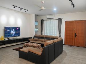 a living room with a couch and a flat screen tv at CEM MIRI HOMESTAY in Miri