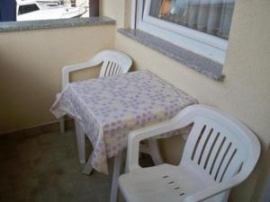 duas cadeiras brancas e uma mesa e uma mesa e uma janela em Appartement in Banjole mit Garten und Grill em Banjole