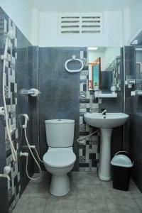 een badkamer met een toilet en een wastafel bij Roam Wings Safari Hotel in Udawalawe
