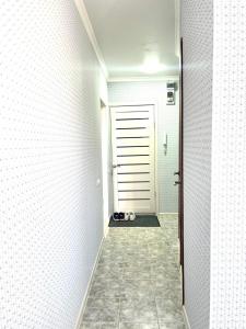 een hal met een deur en een tegelvloer bij 1 комн. кв. 5 микрорайон in Aqtöbe