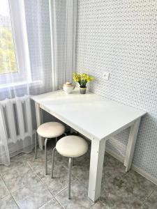 een witte tafel en twee stoelen in een kamer bij 1 комн. кв. 5 микрорайон in Aqtöbe