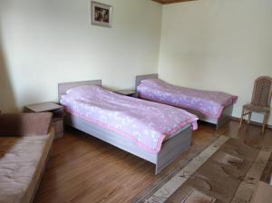 2 camas en una habitación con sofá y silla en Жемчужина Иссык - Куля en Cholpon-Ata