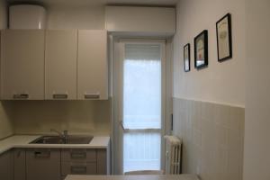 Elle comprend une petite cuisine avec un évier et une fenêtre. dans l'établissement Travelounge Milano San Siro, à Milan