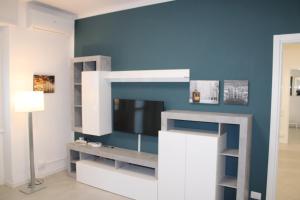 Travelounge Milano San Siro في ميلانو: غرفة معيشة مع تلفزيون على جدار أزرق