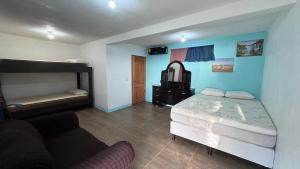 um quarto com uma cama e um sofá em The Wave Hostel Corn Island em Ilhas do Milho