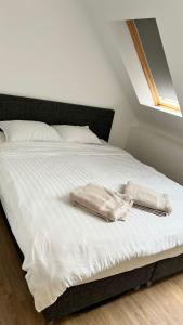 a bed with white sheets and two towels on it at Luxury Escape in Blankenberge
