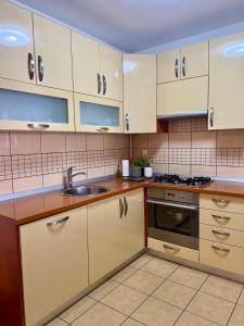 a kitchen with white cabinets and a sink at Arena Cosy apartment in Zagreb