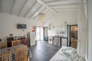 a kitchen with white walls and a large room at Casa Atlantida - Sea front in Faja Grande