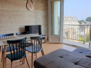 salon ze stołem, krzesłami i telewizorem w obiekcie Bel appartement rénové au centre-ville de PERROS-GUIREC - Réf 920 w mieście Perros-Guirec