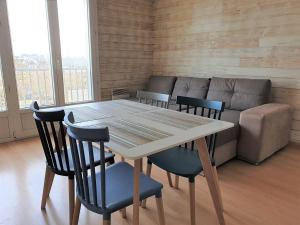 stół i krzesła w pokoju z kanapą w obiekcie Bel appartement rénové au centre-ville de PERROS-GUIREC - Réf 920 w mieście Perros-Guirec