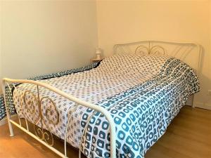 un letto con piumone blu e bianco in una camera da letto di Maisonnette à 150m du centre-ville et des commerces à PERROS-GUIREC - Réf 922 a Perros-Guirec