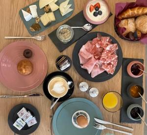 una mesa de madera con platos de comida y café en B&B NALÙ, en Arco