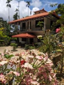 a house with pink flowers in front of it at Vasu estate stay in Madikeri +24 photos