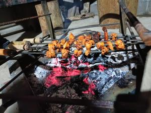 a bunch of food cooking on a grill at Vasu estate stay in Madikeri