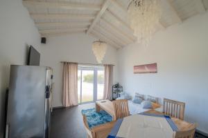 a kitchen and dining room with a table and a refrigerator at Casa Atlantida - Sea front in Faja Grande