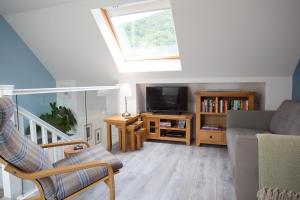 a living room with a couch and a tv at View of the Mountain in North Ballachulish
