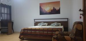 um quarto com uma cama com uma fotografia na parede em Royal Residency em Plaine Magnien