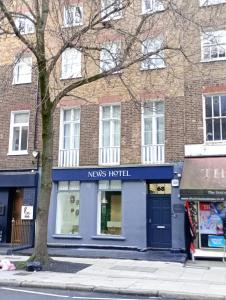 a building with a news hotel sign on a street at Charlotte Street Rooms by News Hotel in London