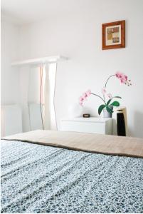 1 dormitorio con 1 cama, mesa y flores en Charming f2- private residence, en LʼÎle-Saint-Denis