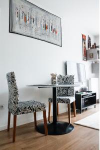 - Sala de estar con mesa y 2 sillas en Charming f2- private residence, en LʼÎle-Saint-Denis