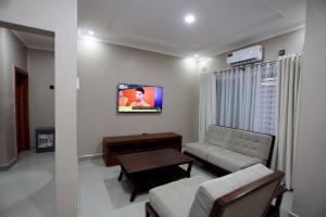 a living room with a couch and a tv at Cloud One Apartments in Kitwe