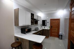 a kitchen with white cabinets and a counter top at Cloud One Apartments in Kitwe