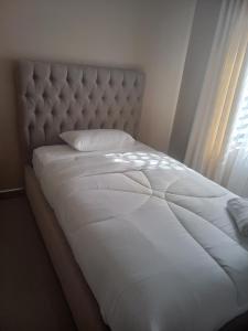 a white bed with a white pillow and a window at Cloud One Apartments in Kitwe