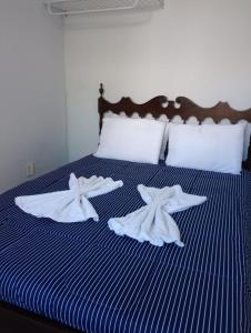 a bed with towels on it with two starfish at Pousada Talho da Serra in Conservatória