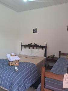 a bedroom with two beds and a table and a chair at Pousada Talho da Serra in Conservatória
