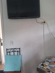Elle comprend une télévision à écran plat suspendue sur un mur blanc. dans l'établissement Pousada Talho da Serra, à Conservatória