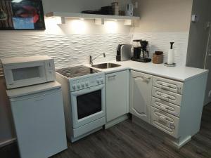 a kitchen with a stove and a microwave at Penthouse with a balcony in Hyvinkää