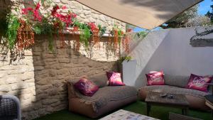 patio z kanapą i kwiatami na ścianie w obiekcie Le mas des mourguettes w Saintes-Maries-de-la-Mer